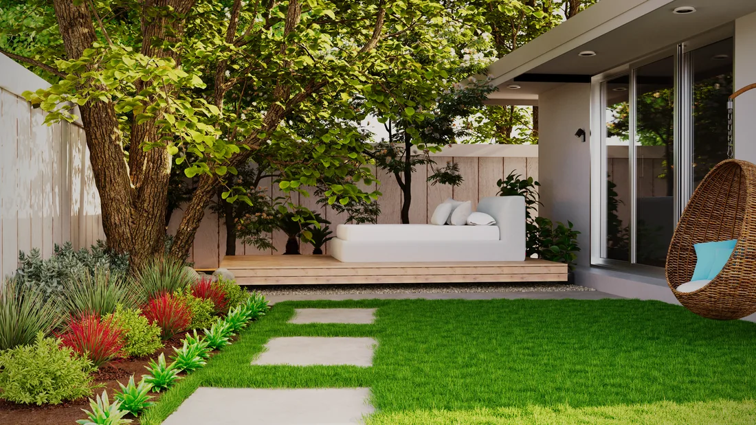 A modern back garden with a paved path, planting bed and small lawn